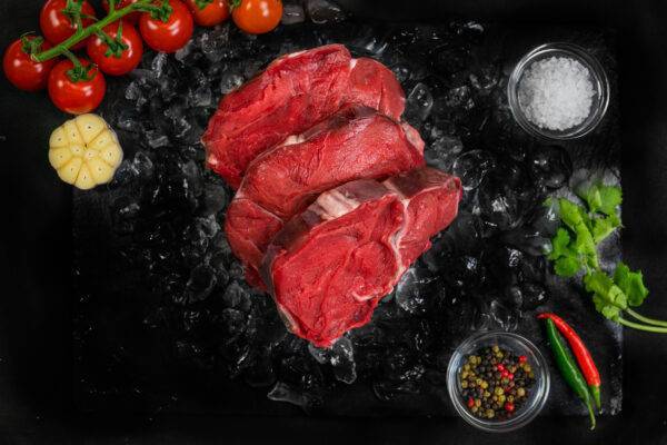 3 cuts of beef shin on a bed of ice, surrounded by garnishes