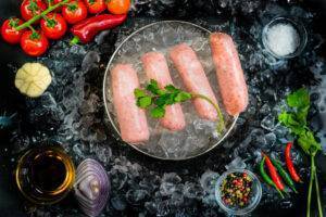 4 pork sausages surrounded on ice, surrounded by garnish