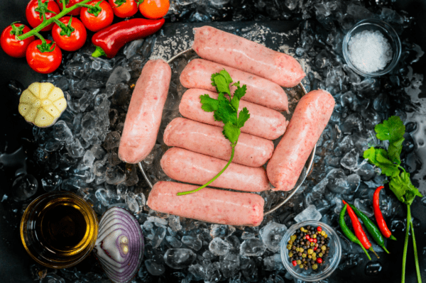 pork sausages on a bed of ice surrounded by onion and garnish