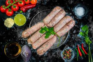 pork and leek sausages on a bed of ice surrounded by garnishes