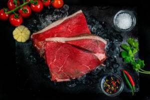 3 cuts of rump steak on a bed of ice surrounded by garnishes