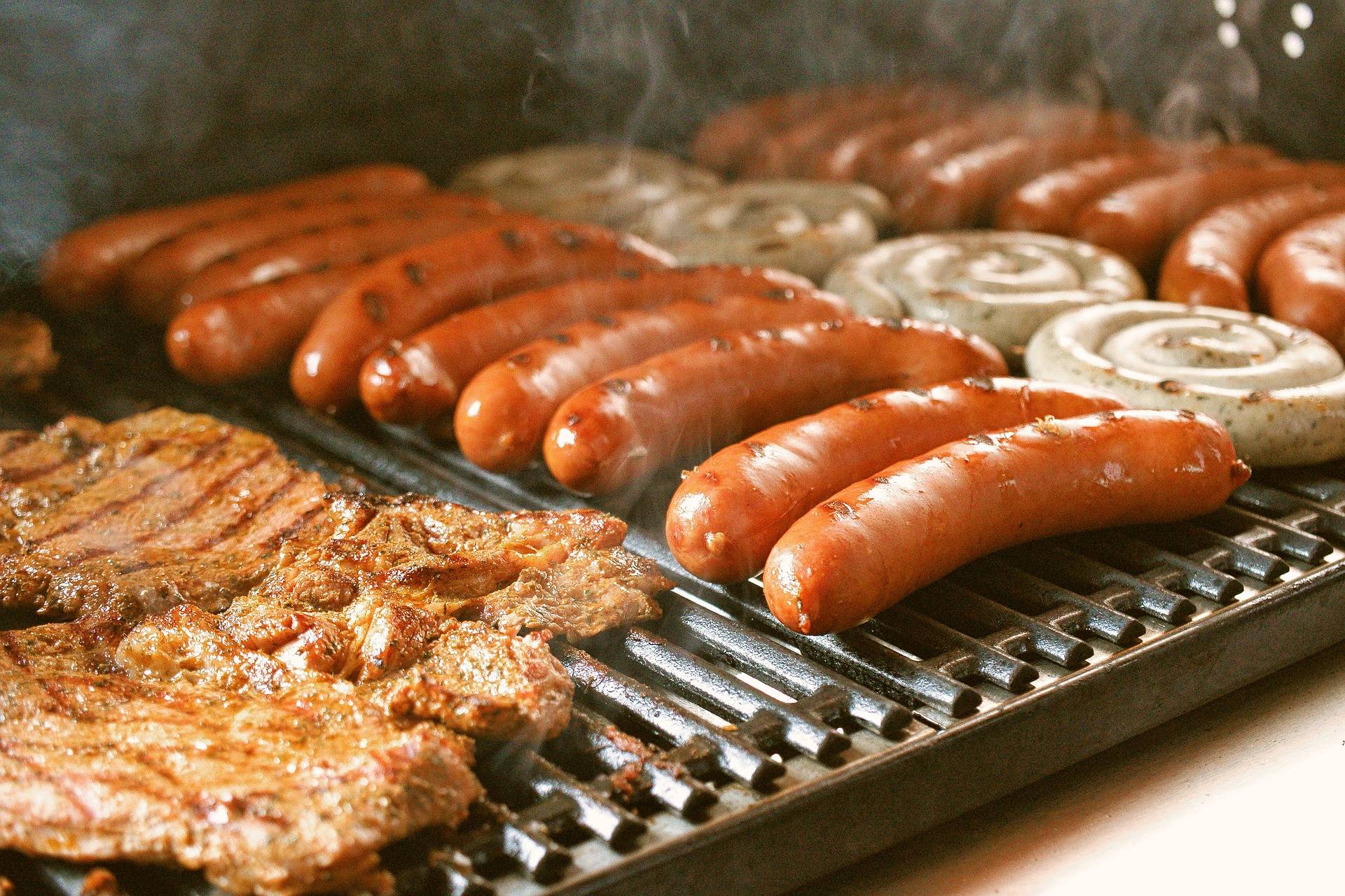 rows of sausages and meat on a bbq
